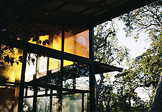 house with clear and orange windows surrounded by trees