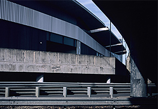 grey building and road barriers under an overpass