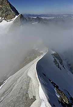 snowy mountain covered in cloud